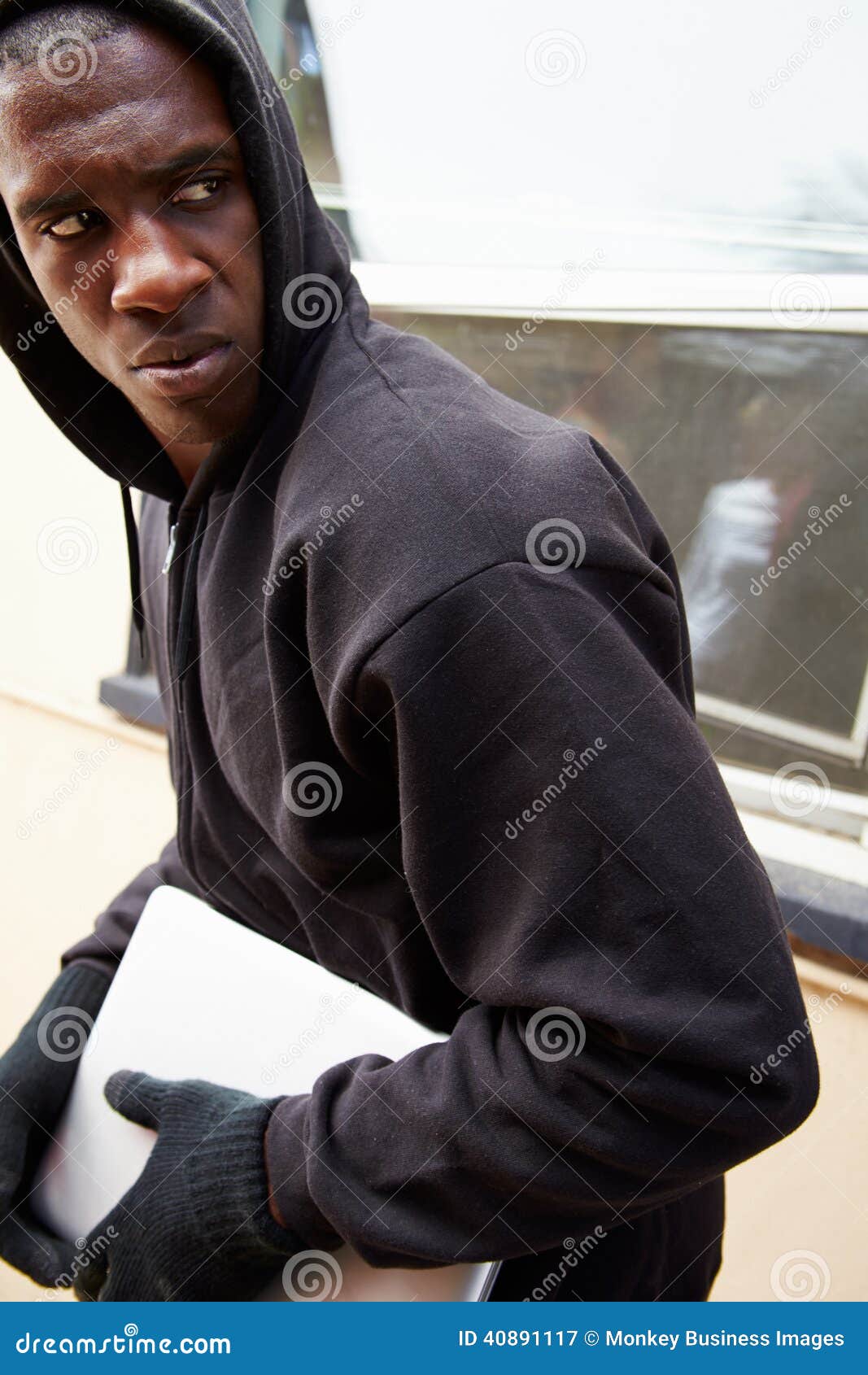 young-man-breaking-house-stealing-laptop-close-up-wearing-black-hooded-jacket-40891117.jpg