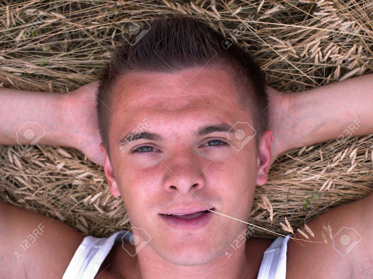 7379980-portrait-of-a-young-man-with-a-straw-in-his-mouth-on-a-hay-background.jpg